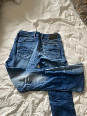 Blå super low waisted bootcut jeans - Säljer ett par blå low waisted bootcut jeans med tvättade detaljer. Materialet är stretchigt denim som sitter skönt och formar sig efter kroppen. Perfekta för en avslappnad och trendig look!!💖💖Passar xs och s