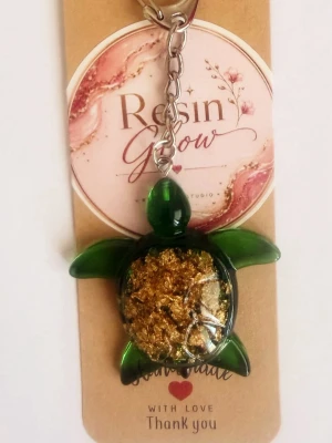 Nyckelring sköldpadda i resin - Unik nyckelring formad som en sköldpadda i resin med inslag av guldflingor. Finns i grönt och blått, med metallkedja och ring. Perfekt accessoar för att piffa upp väskan eller nyckelknippan.