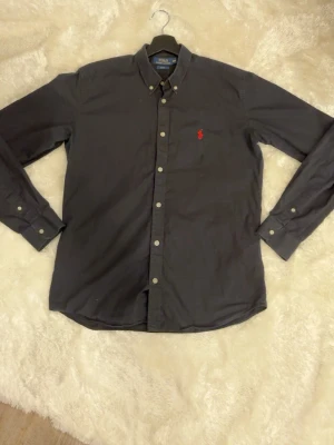 Polo Ralph Lauren skjorta - Svart skjorta från Polo Ralph Lauren i slim fit med rött märke. Skjortan är storlek M