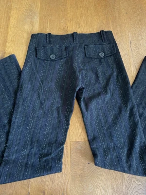 Midwaist bootcut kostymbyxor  - Vintage kostymbyxor från F&K. Glittriga ränder samt lite stretch. Midja: 39 cm. Innerben: 86 cm. 
