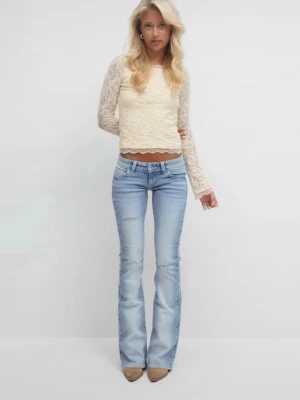 Ljusblå bootcut jeans med slitningar - Säljer ett par ljusblå bootcut jeans med låg midja och diskreta slitningar på benen. Jeansen har klassisk femficksdesign och är tillverkade i denim med lite stretch för skön passform. Perfekta för en avslappnad och trendig look.