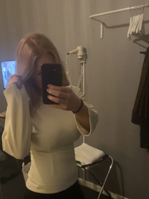 Vit långärmad topp med markerad midja  - En krämvit figur sydd blus, tjockt material. Använd några gånger, tröjan är ifrån marville road - ny pris 2000