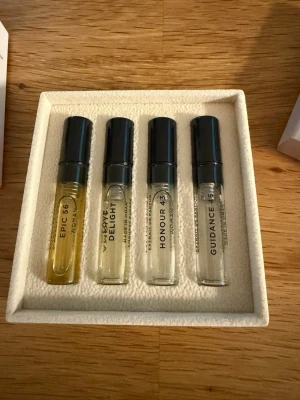 Amouage parfymprovset 4x2ml - Exklusivt provset från Amouage med fyra olika dofter: Epic 56, Love Delight, Honour 43 och Guidance 45. Flaskorna är små, cylinderformade och genomskinliga med svarta lock, levereras i en elegant ljus ask med mönstrad yta. Perfekt för att upptäcka lyxiga parfymer.