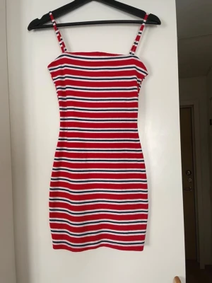 Oanvänd röd randig ribbad klänning - Randig ribbad klänning med prislappen kvar, 99kr i nypris. Från H&M. Banden går inte att justera. Den är liten i storleken så den passar de som brukar ha XS-S även om den är i storlek 38/medium. Går en bit under rumpan på mig som är 173cm.