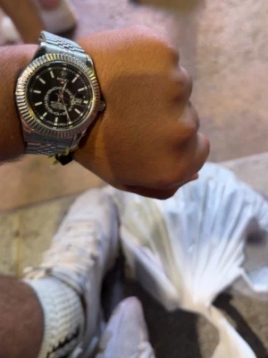 Rol3x Stilren silverfärgad klocka rol3x - Snygg klocka i silverfärgat metallarmband och svart urtavla med vita detaljer. Klockan har en klassisk rund form och robust länkarmband som ger en tidlös look. Perfekt accessoar för att lyfta din outfit.