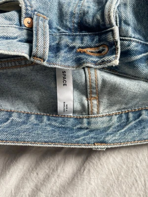 Weekday Space Relaxed Straight Jeans - Ljusblå jeans från Weekday i modellen Space Relaxed Straight. Jeansen har raka ben, avslappnad passform och klassiska kontrastsömmar. Tillverkade i bomull och perfekta för en chill och trendig look.