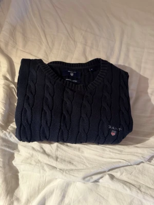 GANT Kabelstickad tröja - Mörkblå Kabelstickad i fint skick. Passar ej mig längre och säljes därför. Storlek M.