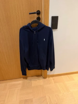 Mörkblå zip hoodie från Ralph lauren - Snygg mörkblå zip hoodie från Ralph Lauren. I stort sätt oanvänd. Inga defekter. Skicka 9/10. Passar året runt.