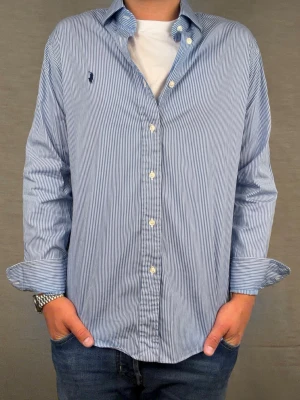 Ralph lauren skjorta M vit/blå randig - Säljer denna otroligt snygga ralph lauren skjorta. Riktigt skönt material . Size 15 1/2 som motsvarar M. Modellen är 180cm. Bredd 46cm,  längd 71cm! Fint skick, nytvättad och ny strykt så att skillnaden på denna och en ny ska vara minimal! Fraktar samma dag som köp, kan gå ner i pris vid snabb affär! 🤩