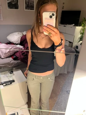 Gröna bootcut jeans med låg midja, short längd.  - Säljer ett par gröna jeans med låg midja och bootcut passform. Jeansen har klassisk femficksdesign, knapp och dragkedja framtill. Perfekta för en avslappnad och trendig stil. De är från lager 157 och är lite slitna nertill då de är nedsydda till lågmidjat. De är även kortare i modellen. Jag är  160cm.