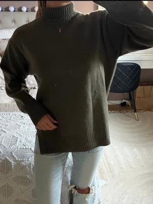 Olivgrön polotröja i stickat - Säljer en olivgrön stickad polotröja med hög krage och långa ärmar. Super fin nu inför hösten