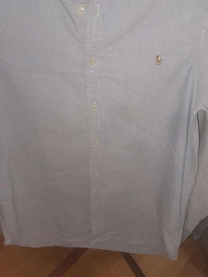 Ljusblå skjorta från Ralph Lauren - Klassisk ljusblå skjorta från Ralph Lauren med button-down krage och broderad logga på bröstet. Skjortan har långa ärmar och knappar framtill. Perfekt till en clean och stilren look.