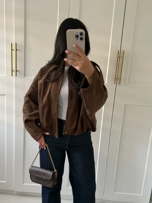 Brun mockajacka med dragkedja - Säljer denna väldigt eftertraktade mockajackan från Zara, med dragkedja framtill. Jackan har en loose passform och klassisk krage,. Materialet är mjukt och bekvämt. Passar till många olika outfits. Min favorit jacka❤️ men måste tyvärr sälja. Den har inga defekter. Köptes för 700kr, storlek S