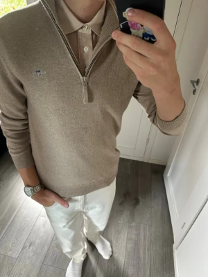 Gant half zip sand färgad - Stilren och klassisk Half-Zip från GANT. Ett väldigt lättmatchat plagg som passar bra med både jeans och chinos. Jag är 180 cm / 70 kg och bär storlek S på bilderna.  Tröjan är i mycket fint skick utan defekter. Inga fläckar, hål eller andra skador.  Modell: GANT Half-Zip Storlek: S Nypris: ca 1 700 kr Skick: Mycket fint skick  Mått:  * Längd: 67 cm * Bredd: 46 cm * Ärmlängd: 61 cm  📦 Postas inom 24 timmar! 📸 Se bilder för skick och passform.