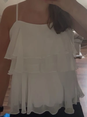 Volang topp från Lindex  - Jätte söt volangtopp från Lindex. Använd ett par gånger men i nyskick. Den är inte alls genomskinlig och har ett lager under. Sitter som en S trots barnstorleken. Kom gärna med prisförslag!💗