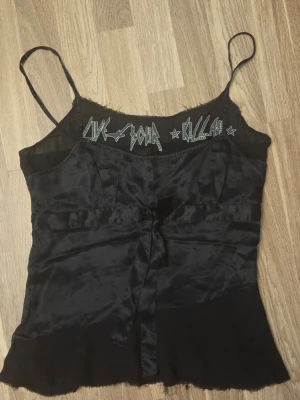Killah linne 100% silke - Snyggt linne från Killah i 100% silke. Dekorativt band fram och en lite genomskinlig panel med text fram åvanför bysten. Sömmarna har en "raw" stil med en del trådar som sticker ut. Jag köpte linnet second hand och är därför osäker på om det var så från början eller om det är designat så. Därför har jag markerat "bra skick".