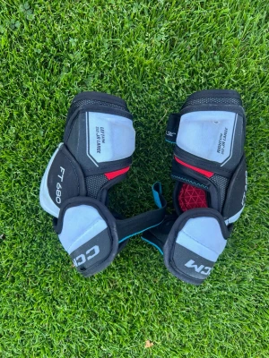 CCM FT680 armbågsskydd hockey - Säljer ett par svarta, gråa och röda armbågsskydd från CCM, modell FT680. Skydden har justerbara remmar och vaddering för extra komfort och skydd vid hockeyspel. Perfekta för dig som vill ha bra skydd på isen.