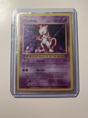 Pokémonkort Mewtwo holografisk - Säljer ett Pokémonkort med Mewtwo-motiv, holografisk yta och lila ram. Kortet har engelska texter och är inplastat i ett skyddsfodral. Perfekt för samlare eller Pokémonfans som vill utöka sin samling.