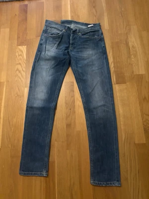 Dondup jeans - Säljer ett par blå jeans från dondup med raka ben och lätt slitna detaljer. Jeansen har klassisk femficksdesign och kontrastsömmar. Materialet är denim i bomull och de har en avslappnad passform som funkar till det mesta.