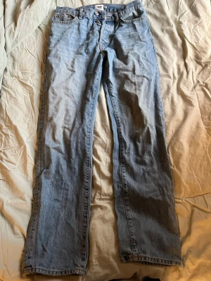 Ljusblå raka jeans från 157 - Säljer ett par ljusblå jeans från 157 med rak passform och klassisk femficksdesign. Jeansen har normal midja och är tillverkade i denim med en snygg tvätt. Perfekta för en avslappnad och trendig stil.