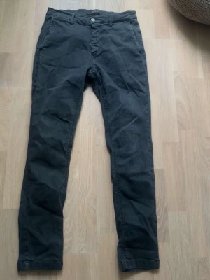 Svarta Replay hyperflex jeans - Snygga svarta jeans med smal passform och klassisk design. Byxorna har framfickor, bälteshällor och knäppning med knapp och dragkedja. Tillverkade i ett mjukt bomullstyg som ger en skön känsla. Perfekta för en stilren och avslappnad look.