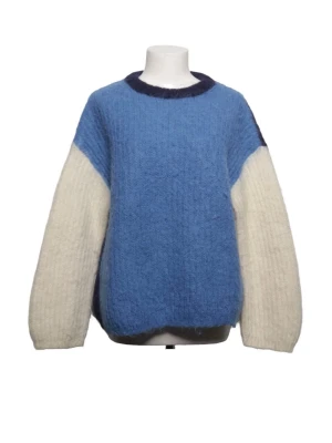 Blå och vit oversized stickad tröja - Säljer en oversized stickad tröja i blått och vitt med mörkblå detaljer. Tröjan har breda, långa ärmar och en mjuk, fluffig struktur. Perfekt för dig som gillar en avslappnad och trendig look. Materialet ser ut att vara en ull- eller mohairblandning.