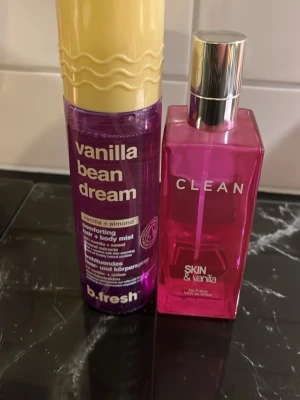 Clean vanilla Vaniljdoftande parfymer duo - Två parfymer med vaniljtema: en lila hår- och kroppsmist 'vanilla bean dream' med vanilj och mandel, samt en rosa Eau Fraîche 'SKIN & vanilla' från CLEAN. Båda flaskorna har modern design och tydliga etiketter. Perfekt för dig som älskar söta, mjuka dofter.