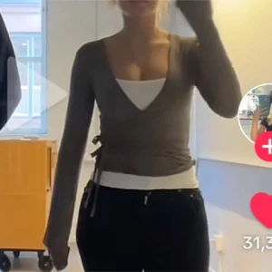Omlottopp - Snygg gråbeige omlottopp med lång ärm och knytning i sidan. Perfekt för en stilren look. Aldrig använd endast testad.