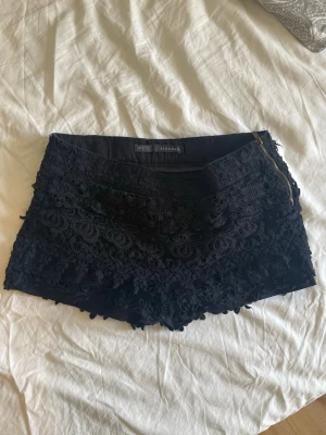 Spets shorts från Zara - Ett par super fina shorts från Zara med låg midja och spets i olika lager. Bra skick, inga skavanker, och 100% bomull. Säljer då de är på gränsen till för små för mig.