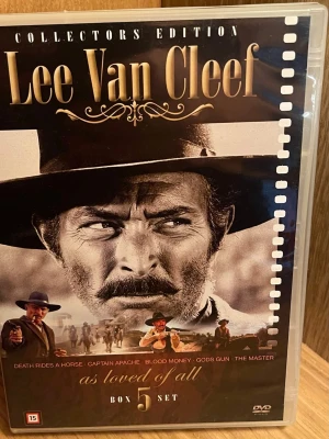 Lee Van Cleef Collectors Edition DVD-box - Samlarbox med fem klassiska westernfilmer med Lee Van Cleef. Innehåller Death Rides a Horse, Captain Apache, Blood Money, God's Gun och The Master. Omslaget är i svart och guld med filmtema och bilder från filmerna. Perfekt för filmälskare och westernfantaster. Perfekt Skick