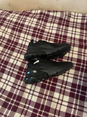 Helvita svarta sneakers med luftsula - Säljer ett par helsvarta sneakers med luftig mesh och syntetdetaljer. Skorna har en chunky sula med synlig luftbubbla i hälen och en sportig siluett. Perfekta för dig som gillar stilrena och moderna sneakers.