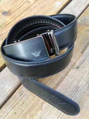Armani Exchange ställbart skinn skärp  - Snyggt svart skärp från Armani i skinn med stilrent metallspänne. Spännet har en borstad finish och en diskret logga framtill. Skärpet har en klassisk design och passar till de flesta outfits.