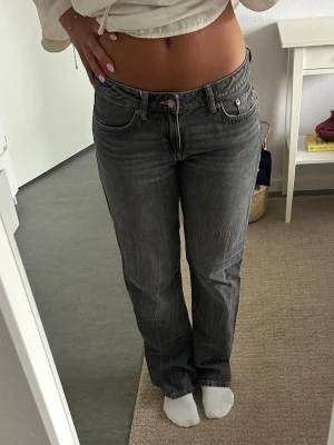 Grå raka jeans med låg midja - Säljer ett par grå jeans med rak passform och låg midja. Jeansen har klassisk femficksdesign, bälteshällor och knappgylf. Materialet är denim i bomull och färgen har en snygg tvättad look. Perfekta till en avslappnad stil. Modell arrow low, 32 i längd