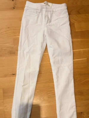Vita skinny jeans från Pieces - Säljer ett par vita skinny jeans från Pieces. Jeansen har klassisk femficksdesign, hällor för bälte och dragkedjegylf. Perfekta för dig som vill ha en clean och fräsch look. Materialet är stretchigt för extra komfort.                                                        Storlek: XS, nästintill nyskick 