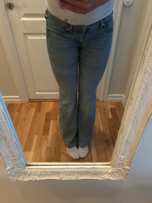 Ljusblå bootcut jeans - Säljer ett par ljusblå bootcut low waist Jeansen har en lätt tvättad look och raka ben som går ut.
