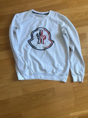 Vit moncler hoodie  - Säljer min vita moncler hoodie i bra skick. Tröjan är i storlek L men skulle säga att den mer sitter som S eller M