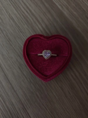 Hjärtring med gnistrande stenar - Ros kristall hjärta ring i storlek 17,3mm, guldfärgad.