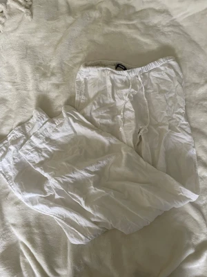 Vita linnebyxor från BikBok XS - Säljer ett par vita linnebyxor från BikBok i storlek XS. Byxorna har resår i midjan och dragsko för skön passform. De är raka i modellen och tillverkade i ett tunt, luftigt linnematerial som passar perfekt till sommaren. Jättefin passform 