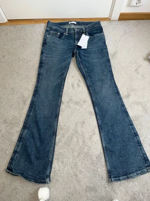 Blå bootcut jeans från Gina Tricot helt ny  - Snygga blå bootcut jeans från Perfect Jeans i klassisk denim. Jeansen har fem fickor, bälteshällor och en lätt utsvängd passform nedtill. Perfekta för dig som gillar en retroinspirerad look och vill ha ett par jeans som sticker ut lite extra.