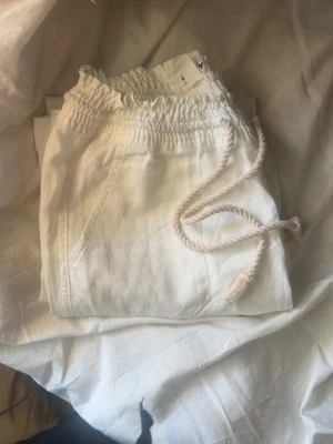 Vita linnebyxor från Roxy - Säljer ett par vita linnebyxor från Roxy med bred resår i midjan och snörning framtill💕, dom är helt nya och enbart testade, säljer pga för små och är för korta då ja är 170💕