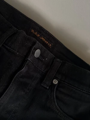 Svarta slim fit jeans från Nudie Jeans - W29 L32 Men passar W28 mycket bättre. Ny skick men lappen där bak råkades göra sönder. 