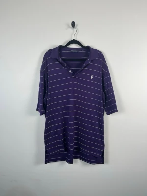 Vintage Polo Golf Ralph Lauren Piké M Lila Randig Pima Cotton Peru 90s Y2K Herr - • Storlek: M • Färg: Mörklila • Passform: Classic Fit  • Krage: Klassisk pikékrage • Material: 100% bomull  Skick: Plagget är i väldigt fint skick. Eventuella anmärkningar anges alltid tydligt i beskrivningen och visas på bilderna.  Nypris: Cirka 1 200 kr.  📦 Skickas snabbt och packas omsorgsfullt. 💬 Hör gärna av dig om du har frågor eller vill se fler bilder. 🤝 Samfrakt erbjuds vid köp av flera plagg – kika gärna in mina andra annonser!