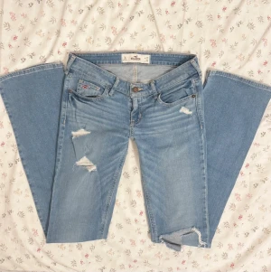 ultra lowrise hollister jeans med revor - jättesnygga hollister jeans finns inte längre att köpa sådana, jeansen är i nyskick, ultra låga med lätt utsvängda ben nedtill bootcut/straight original revor och hål design  passar xs/s bekväma med stretch W26  midja 36 innerben 84,5