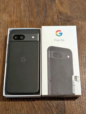Google Pixel 8a svart Android-mobil - Säljer en Google Pixel 8a i svart med stilren design och rundade hörn. Telefonen har dubbla kameror på baksidan och en matt finish. Levereras i originalkartong. Perfekt för dig som vill ha en smidig och modern Android-telefon.