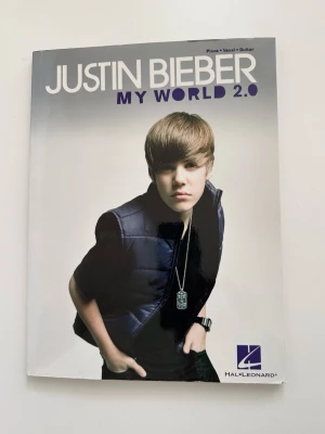 Justin Bieber: My World 2.0 - Noter och sångbok - Noter och sångbok för piano, sång och gitarr av låtar från Justin Biebers bejublade debutalbum "My World 2.0" från 2011, som blev startskottet för hans långa karriär. Innehåller låtar som "Baby" och "Somebody to Love". Perfekt för alla Beliebers, men också för musikintresserade som vill lära sig spela och sjunga några moderna klassiker, eller vill ha en närmare förståelse för musikkomposition. Fint skick!