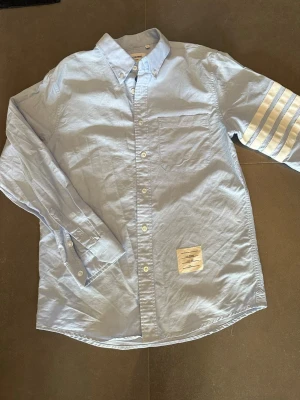 Thom brown skjorta - Ljus blå thom brown skjorta. Size 1 vilket e som S. Skriv om om mått önskas eller om ni vill ha mer info 