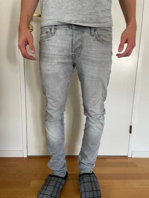 Jack and Jones slim/glenn - Säljer ett par ljusgrå slim fit jeans från Jack and Jones i storlek 29/32. Jeansen är väldigt stretchiga och sköna. De är i gott skick dock ett litet slitage vid en backficka. Säljs för 150kr, hör av er vid frågor!