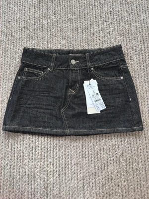Jeanskjol från Gina  - Lågmidjad jeanskjol från Gina tricot. Säljer då den inte kommit till användning. Helt ny med lappar på! Passar till allt. Perfekt nu till sen sommar! 