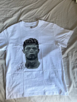 Vit Ronaldo tröja  - Säljer en vit Ronaldo t-shirt, fick den i present nyligen och har aldrig använt den.