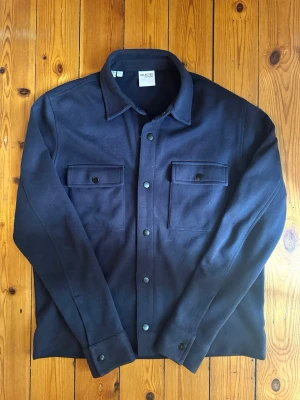 Mörkblå overshirt från Selected Homme - Stilren mörkblå overshirt ifrån Selected Homme med krage och tryckknappar framtill. 